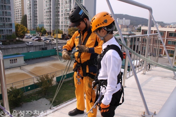 허진욱 구조대원과 동성중학교 학생이 하강레펠체험 전 안전장비를 챙기는 모습
