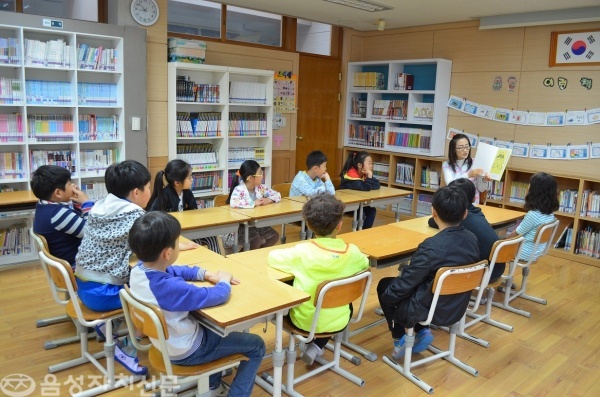 청룡초등학교 한 학부모가 교실을 찾아 아이들에게 동화책을 읽어 주고 있다.