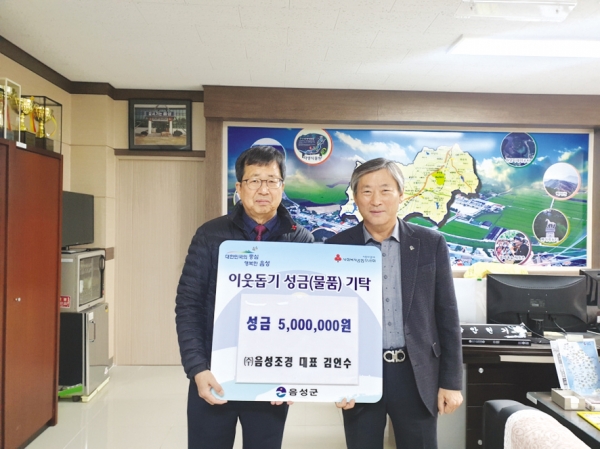 김인수 대표가 안현기 원남면장에게 성금 500만 원을 기탁하고 기념사진을 찍고 있다.